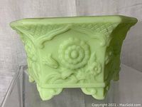 Front angle showing the floral embossed panel and scalloped edges of vintage jadeite planter.