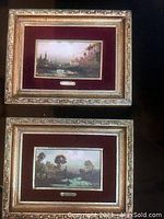 Two mini Gignos pictures with decorative gold-tone frames and maroon mats shown from front view on dark background