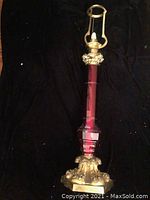 Full view of antique sanctuary lamp showing red glass body and ornate brass base and top fixture.