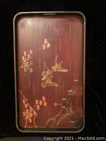 Top view of vintage Chinese TV tray showing painted design of birds and flowers in gold and pink on reddish-brown background.