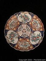 Top view of the front of the Japanese gold Imari hand painted porcelain plate showing intricate multicolored floral and geometric design with gold highlights.