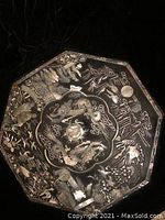 Front side of octagon snack tray showing intricate metal engraving with dragons, birds, and floral elements.