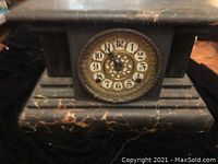 Front view of the vintage mantel clock showing the clock face with Arabic numerals and faux marble pattern on the case.