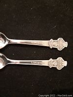 Two silver plated souvenir demitasse spoons, handle side showing 'Lucerne' engraving and Bucherer emblem with crest on each spoon handle.