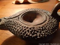 Top view showing hobnail textured surface, central fill hole and spout wick hole