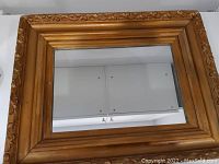 Full view of the rectangular antique mirror with carved wooden frame, showing overall condition and frame details.