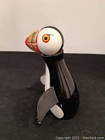 Side profile of puffin figurine on black surface