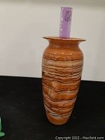 Side view of brown and beige marbled blown glass vase with ruler for scale showing about 9 inches tall.