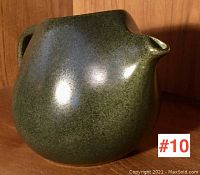 Front view of a green glazed Roseville pottery pitcher with integrated spout and textured matte finish.
