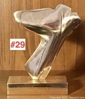 Front three-quarter view showing the abstract upper section and rectangular base