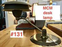 Side view of Mid-Century Modern desk lamp on wooden table with visible brass fittings and metal shade.
