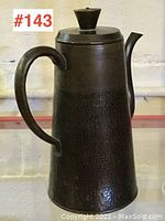 Full view of the hammered brass coffee pot with lid on, showing overall shape and texture.