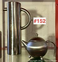 Photo showing both the tall pitcher and round teapot together for scale and comparison