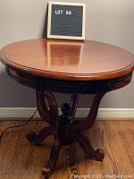 Full view of vintage round wooden end table with decorative legs and smooth polished surface