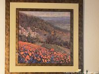 Close-up of the framed print showing the floral poppy field, village, and part of the frame and matte