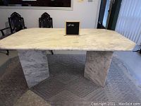Front angled view of the marble table showing surface and legs.