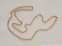General view of rope chain necklace laid out on white background