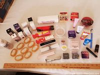 Full overview of all items laid out, showing cosmetics, soaps, fragrance products, and wax melts with a measuring ruler below for scale.