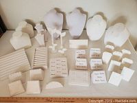 Wide shot of all white jewelry display stands showing busts, ring holders, earring stands, and bracelets displays.