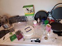 Photo showing assorted kitchen items including Oster blender base, tart pans, donut pan, glass jars, cake pans, cutter, and George Foreman grill.