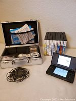 Overall view of console, case, chargers, stylus and boxed games