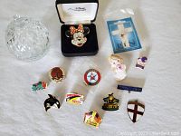 All items arranged on white surface including pins and small covered glass jewelry dish.