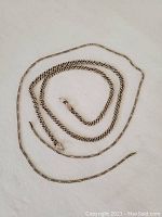Two sterling silver chains laid out showing overall length and condition with visible missing clasp and missing connecting ring.