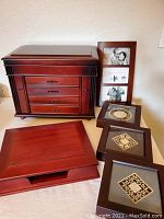 Full lot showing the large jewelry box with drawers, dresser box, triple photo frame, and three square Bible verse frames on table.