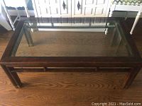 Full tabletop view showing rectangular glass in wood frame on hardwood floor.
