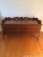 Front view of closed cedar chest showing carved details and cabinetry style build