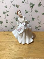 Front view of Royal Doulton Carol porcelain figurine in white dress holding fan.