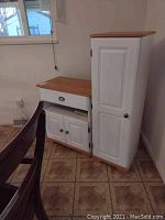 White cabinet set with butcher block tops in corner near window and dining chairs. Shows one shorter cabinet with drawer and double-door storage and one tall cabinet with single door.