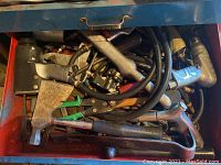 Drawer with various metal hand tools including hammers, pliers, cutting tools and rivet guns.