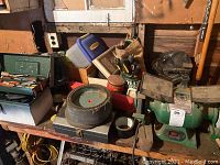 Workbench with various tools including hand tools, a grinder, and assorted items