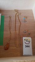 Overhead view of two necklaces, two rings and two pairs of earrings on wood surface