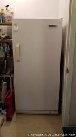 Exterior front view of white upright freezer closed