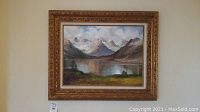 Frontal view of framed oil painting showing the full mountain and lake scenery.