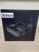 Box of Jinhoo M30 projector showing the model and brand on the packaging