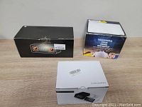 Three boxed items: Bluetooth speaker with alarm clock, LED starry night projector light, and X11 radio alarm clock speaker with temperature display.