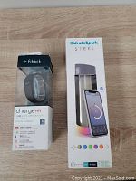 Fitbit Charge HR wristband in original box next to Hidrate Spark Steel water bottle in original box