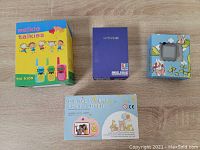Photo showing boxed walkie talkies for kids, Super FC280 NES Family Pocket game box, Digital Camera for Children model D6 box, and PTHTECHUS kids smart watch box with cartoon design.