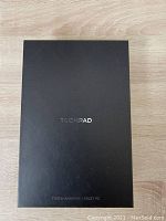 Closed black tablet box with Tronpad branding and 7 inch Android tablet PC label.