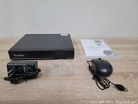 Front and top view of Westshine DVR/NVR unit with included power adapter, screws, USB mouse, and user manual on table.