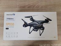 Closed box showing Snaptain SP650 4-axis drone image and model details including 1080P camera and features.