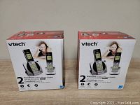 Two unopened retail boxes of Vtech cordless phone sets model CS6919-2, each showing two handsets and brand details on the front.