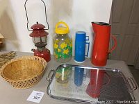 Photo showing all seven items together including lantern, jug, thermos, pitcher, tray, and bread baskets.