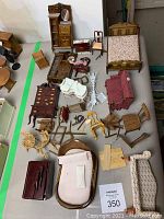 Overview of assortment including beds, chairs, dresser, rocking horse, and broken pieces on a table.