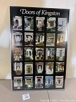Full view of the framed print displaying 25 photos of doors from Kingston, arranged in a grid. Black frame, behind glass.