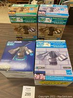 Four boxed Heath Zenith motion security lights on table, showing front product images and packaging.