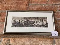 Framed and double matted watercolor painting against a brick wall